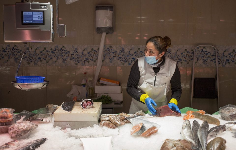 A storekeeper wears a face mask after businesses in Barcelona were given the green light to reopen after weeks of lockdown 