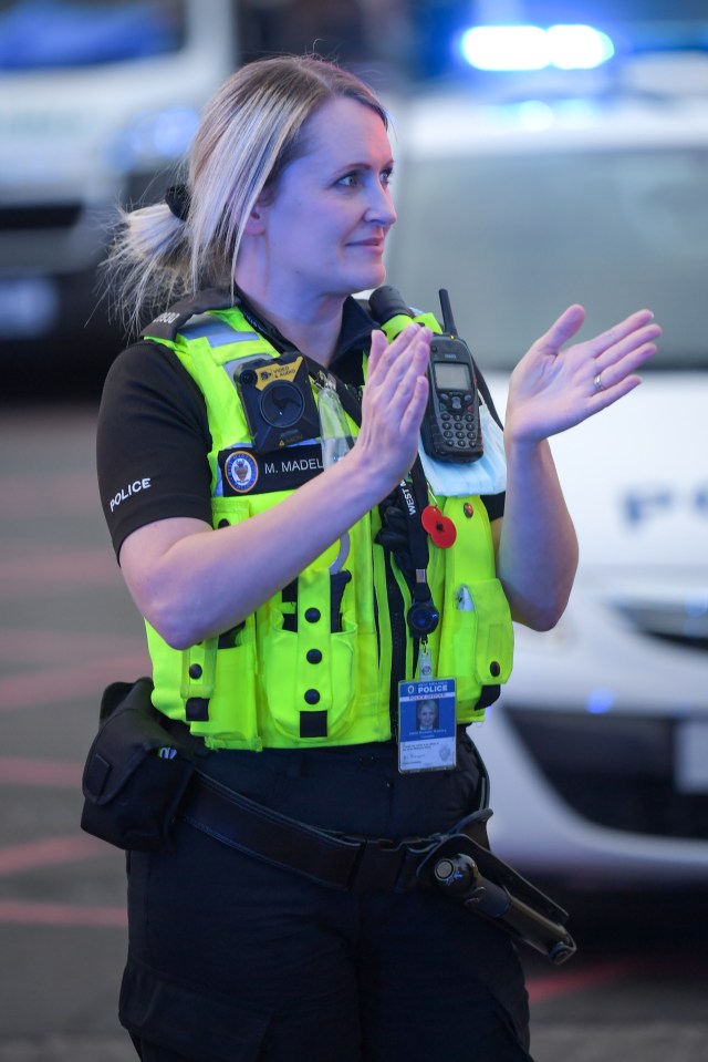  A West Midlands Police officer applauds outside the Queen Elizabeth Hospital in Birmingham