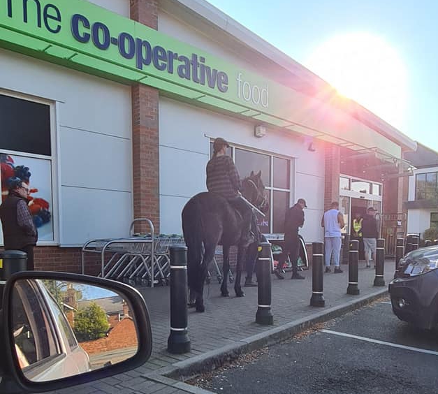  A woman queues for Co-op on her horse