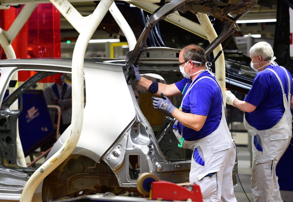  Workers on the assembly line on the first day after work resumed at the Volkswagen factory in Wolfsburg