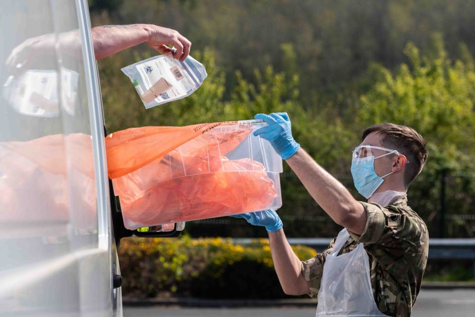  A patients drops a completed self test kit off at a mobile testing unit