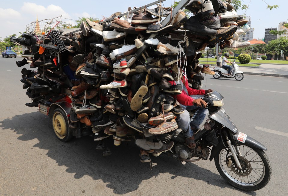  The salesman uses his overladen motorbike to sell shoes in the Cambodian capital of Phnom Pehn