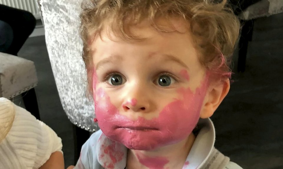  Two-year-old Oscar got into his mum's makeup and covered his face in her pink lipstick