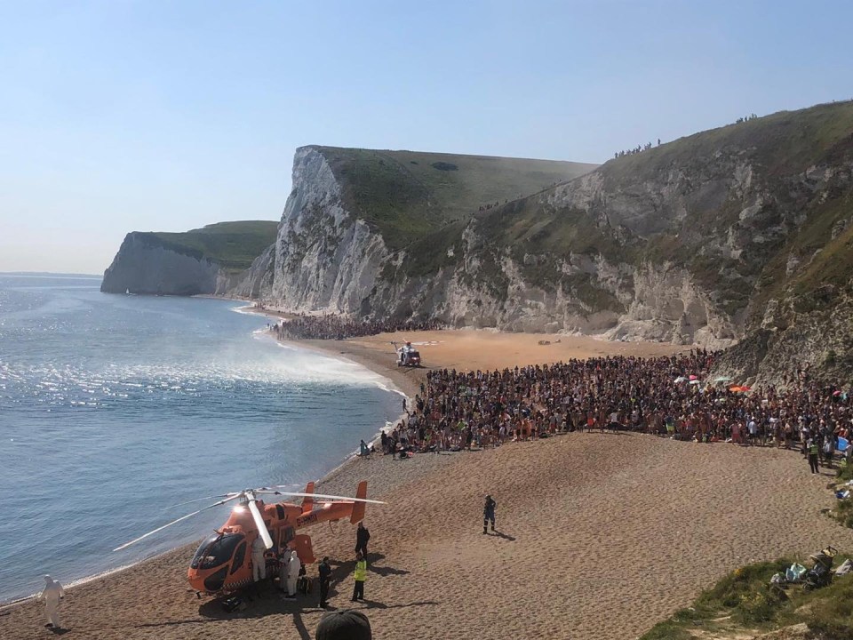 Two images posted by Purbeck Police show huge crowds standing between two helicopters at Durdle Door