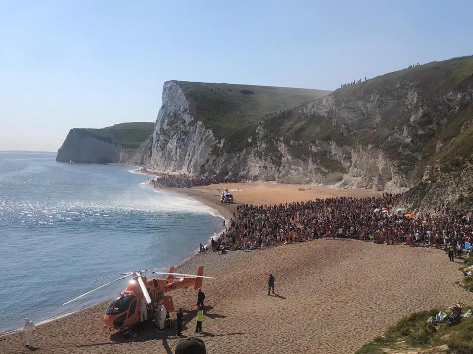  Two images posted by Purbeck Police show huge crowds standing between two helicopters at Durdle Door