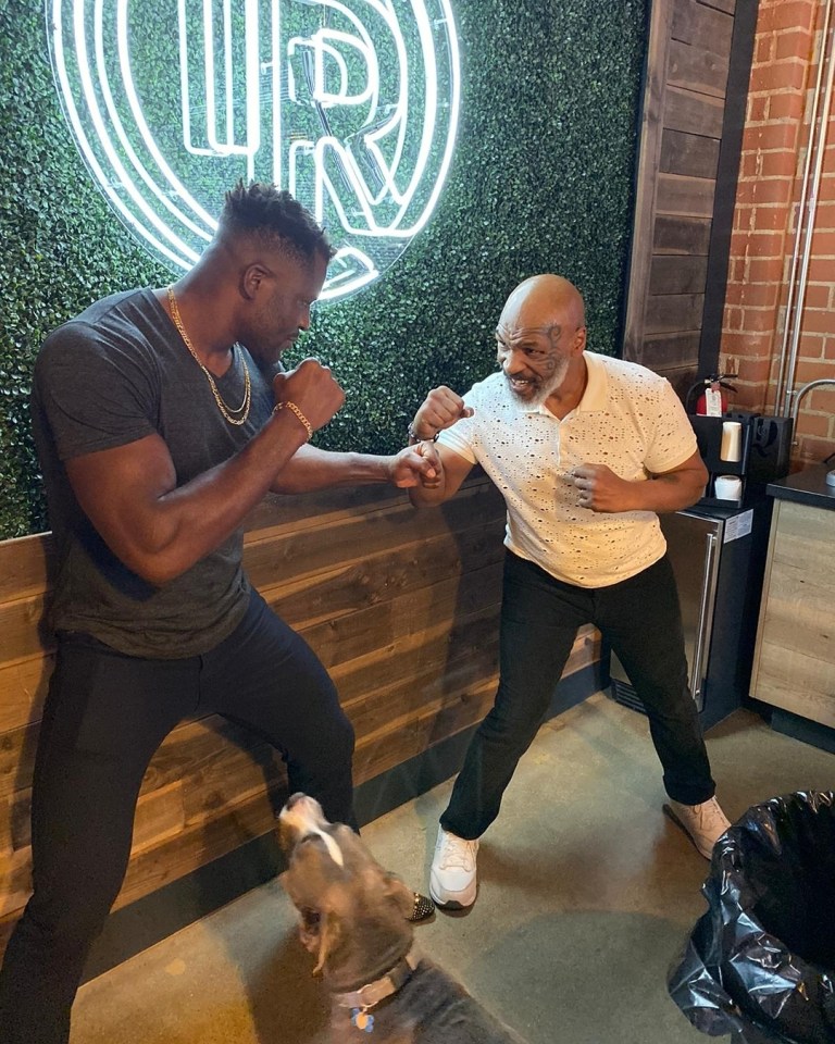 Franics Ngannou towers over his idol Mike Tyson, who has told him get in the head of opponents