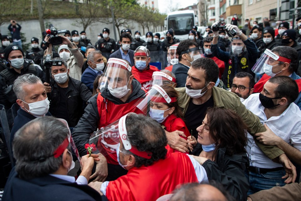  Turkish riot police arrest Arzu Cerkezoglu (C, wearing face shield and mask), the president of Confederation of Progressive Trade Unions of Turkey (DISK) and Turkish Workers Party lawmaker Baris Atay (2-R, wearing face mask, green shirt)