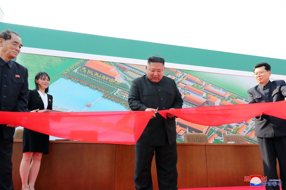  Kim Jong-un cuts the ribbon to his new factory as his sister Kim Yo-jong watches on