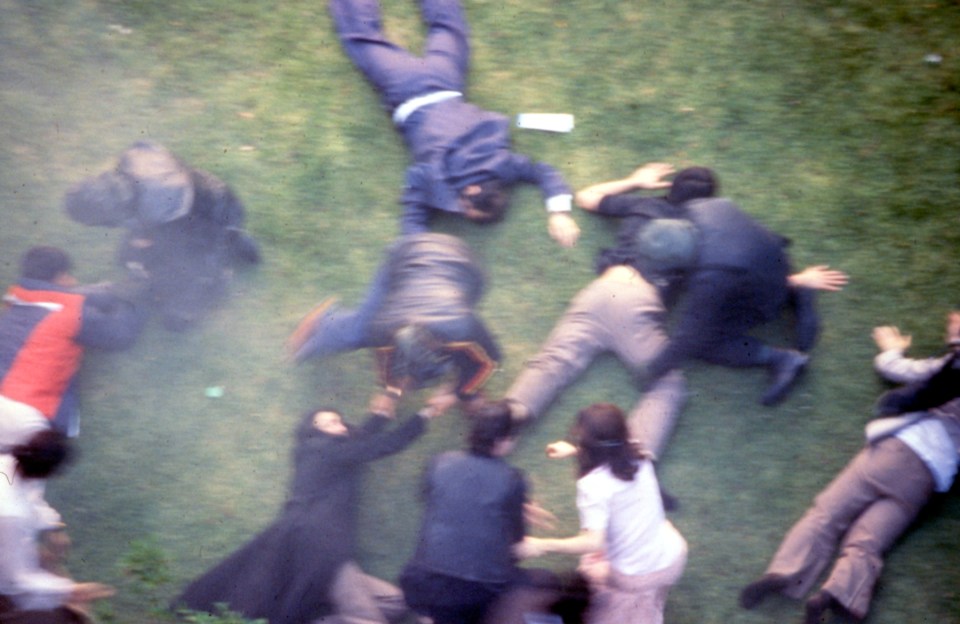 People who were rescued from the embassy lie in a garden nearby