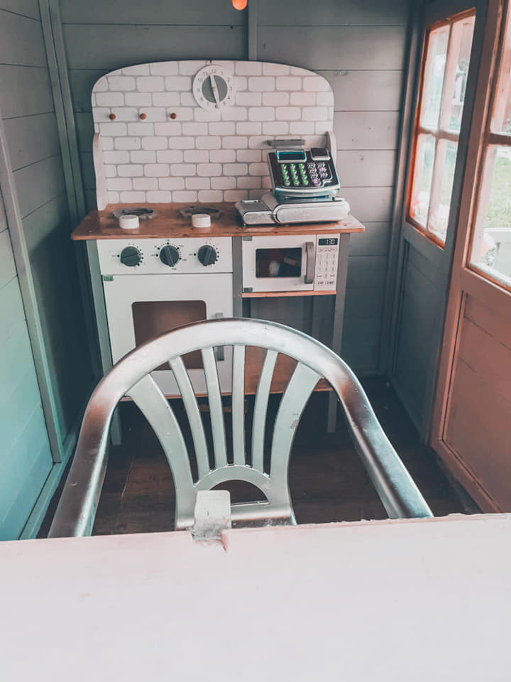  A play kitchen was inside with a garden chair the mum had painted silver