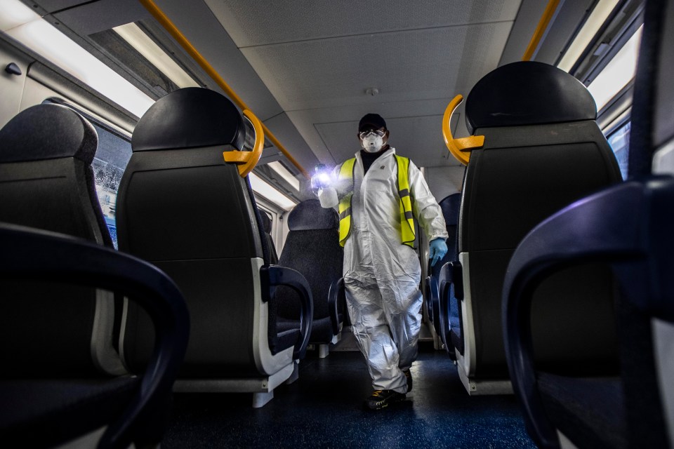  A worker disinfecting a railway carriage