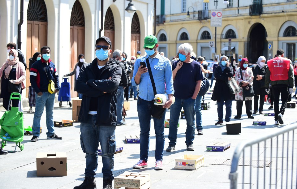  People wearing protective face masks queue at Porta Palazzo market in Turin on May 4