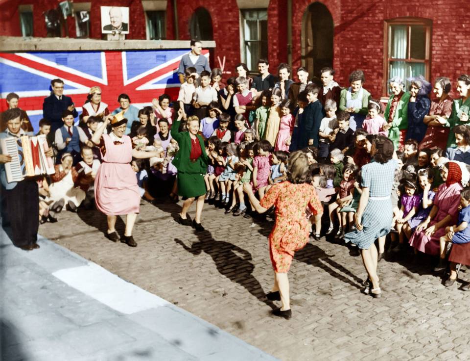  Woman dancing in celebration as children look on in Chorlton-on-Medlock (now Manchester)