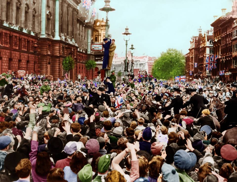  Winston Churchill gives his famous V sign for victory to a huge crowd celebrating near Whitehall, London