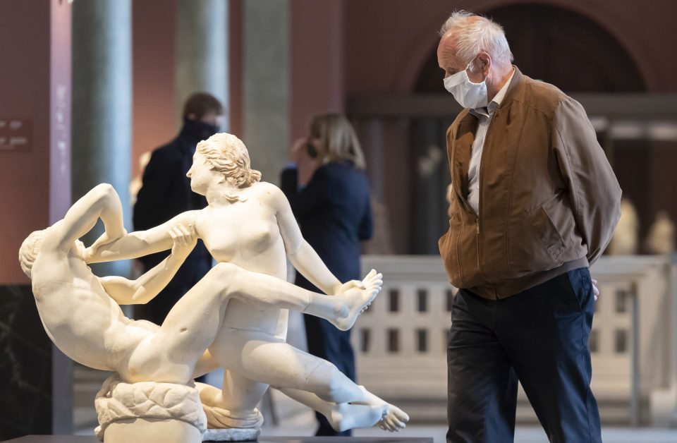  A visitor wearing a face mask walks among sculptures at Zwinger palace in Dresden