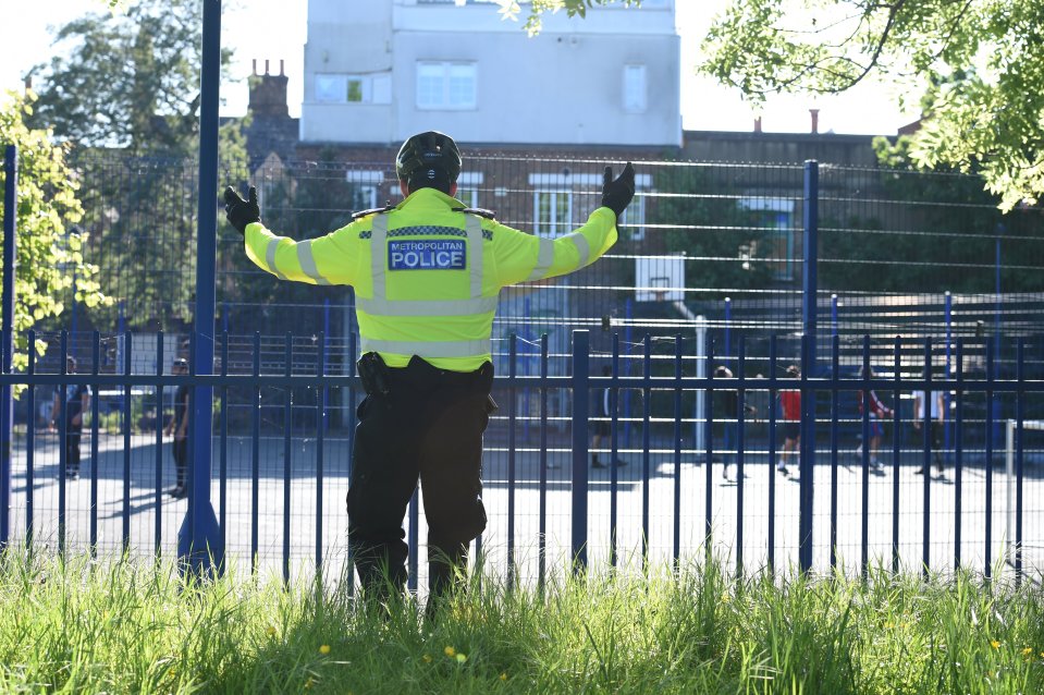  A police officer tells a group of friends playing basketball at Burguess Park to go home