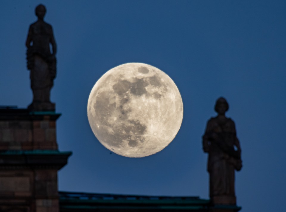  The Full Moon shines between statues on the Bavarian Parliament in Munich, Germany