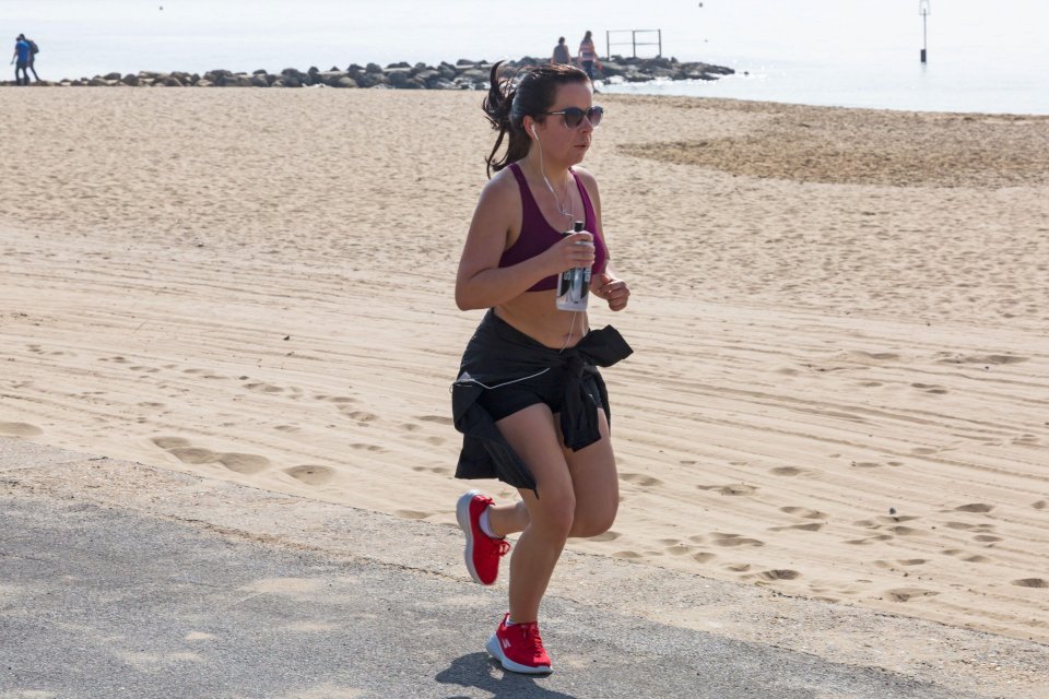  A woman goes for a run along the beach in Poole, Dorset