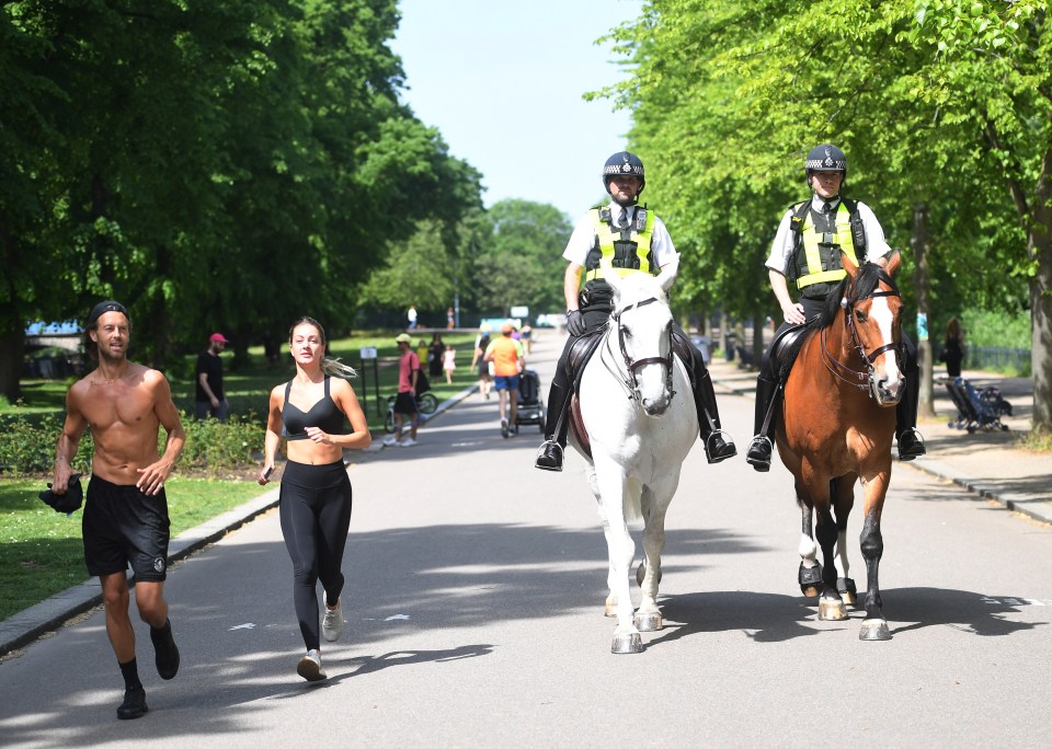  A woman jogs next to police horses monitoring parks across the UK