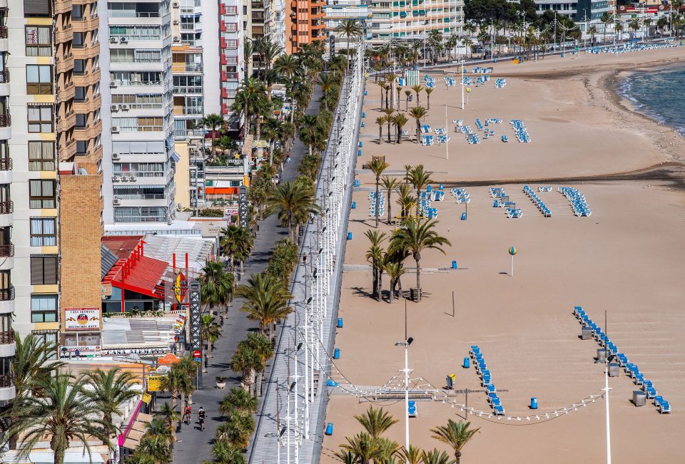  People ride their bikes along the promenade of the closed Playa de Levante Beach on May 11 in Benidorm