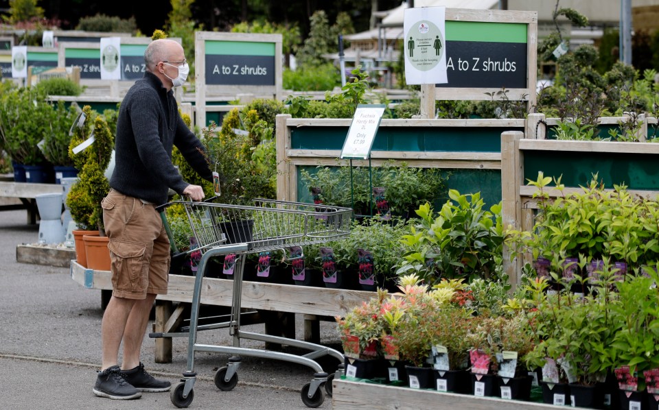  A customer shops near a social distancing sign at Osterley Garden Centre in London