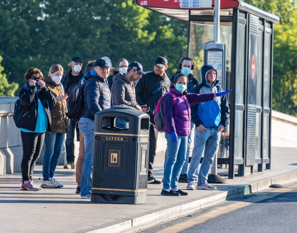  People queued for buses with some in face masks this morning