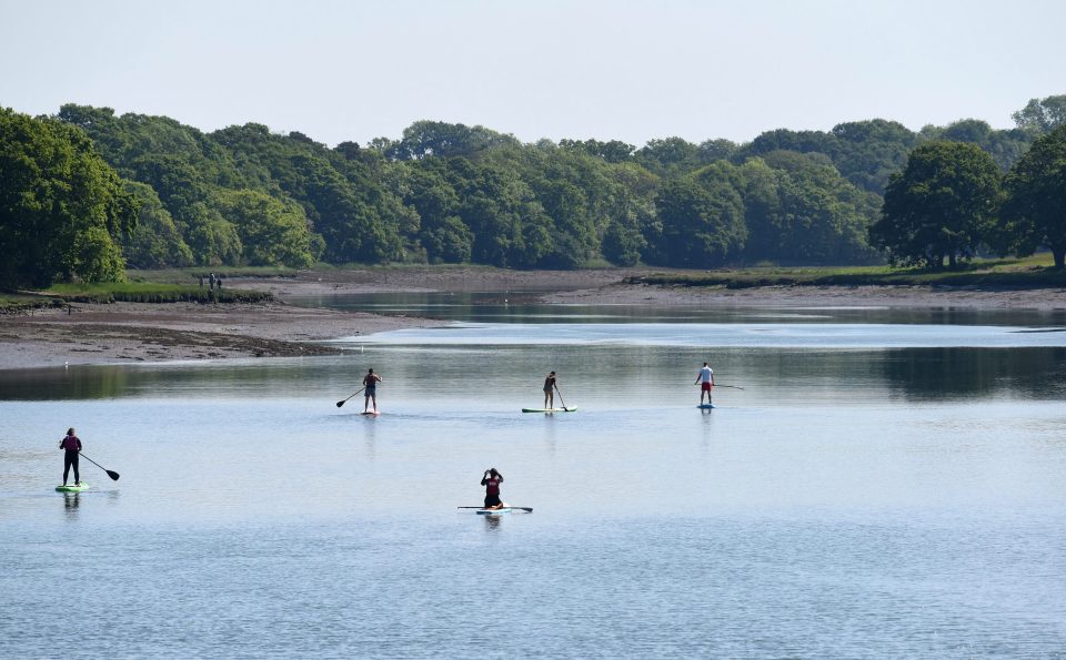  Socially-distanced paddle boarders make their way down the River Hamble, Hants, as the coastguard warns people to stay safe at sea