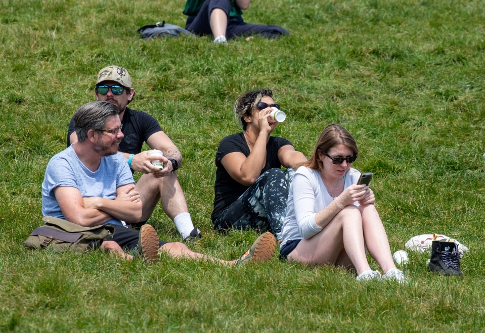  A group enjoys the sunshine on Primrose Hill in North London on Friday afternoon