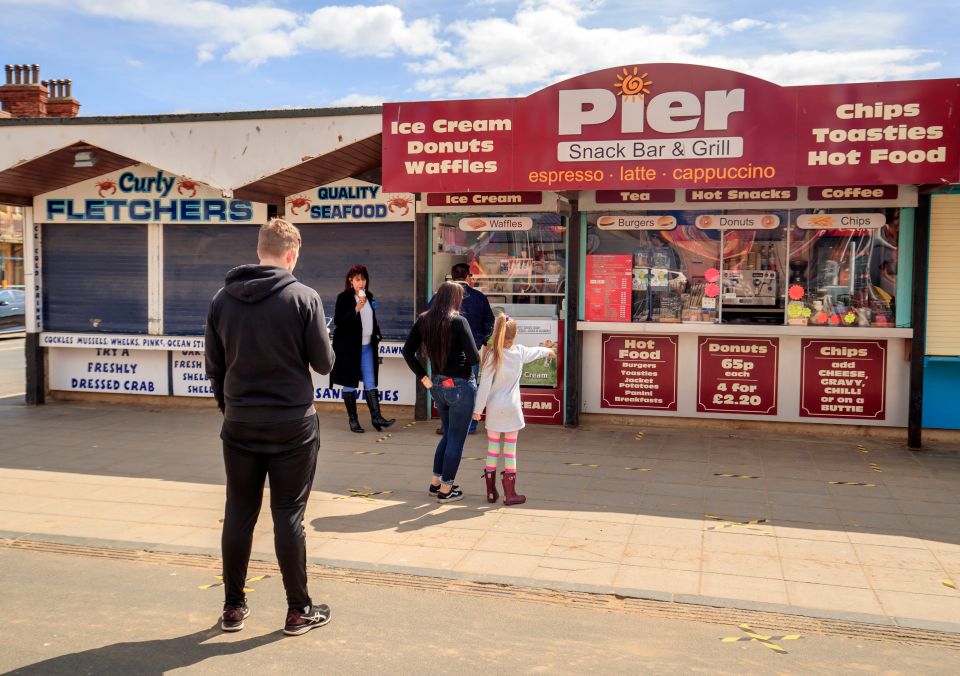  People social distance in the queue at a kiosk near Scarborough beach in Yorkshire