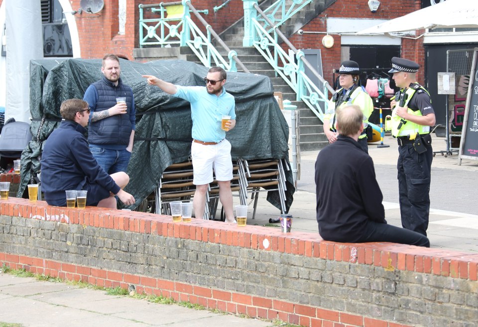 Police speak with men drinking beers in Brighton