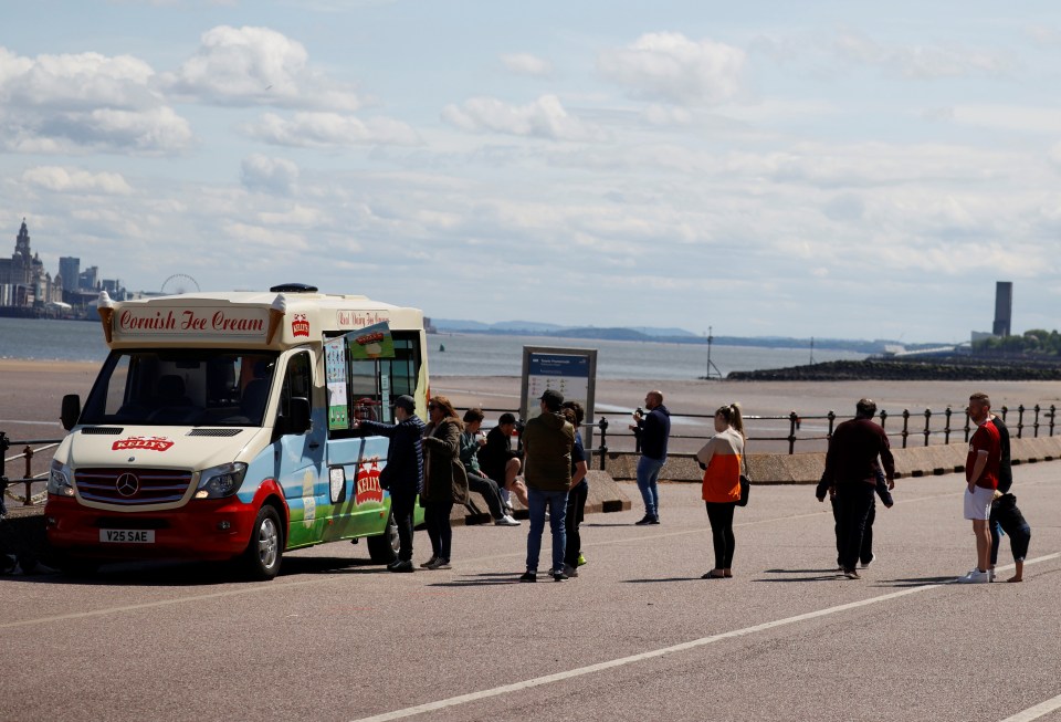 People queue to get ice cream on the beach