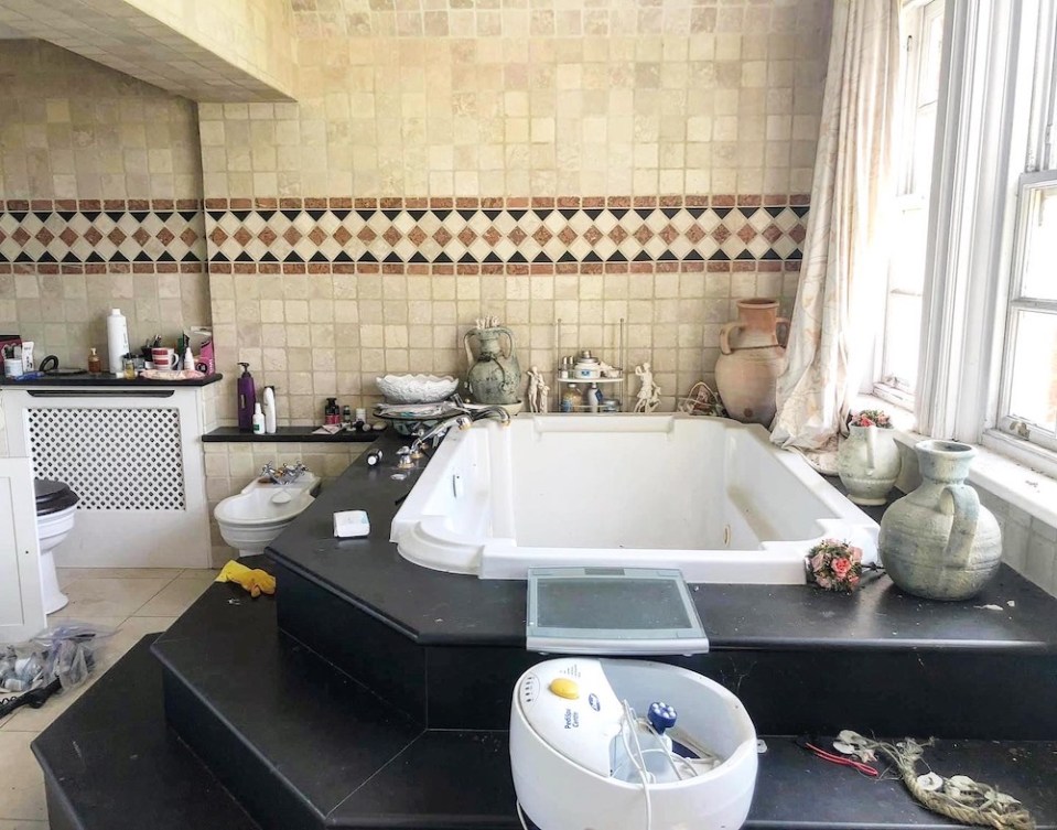  In the bathroom, half-finished bottles of shampoo stand beside a Jacuzzi-style tub