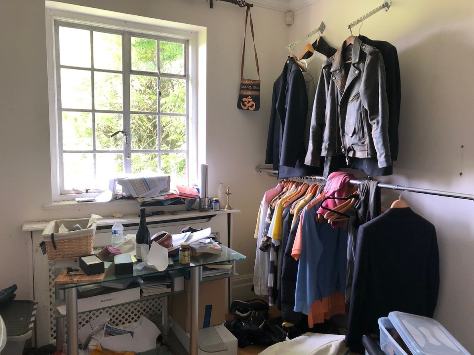  Rails of designer clothes stand in one of the rooms, and the owners left without taking returned dry cleaning out of its bag