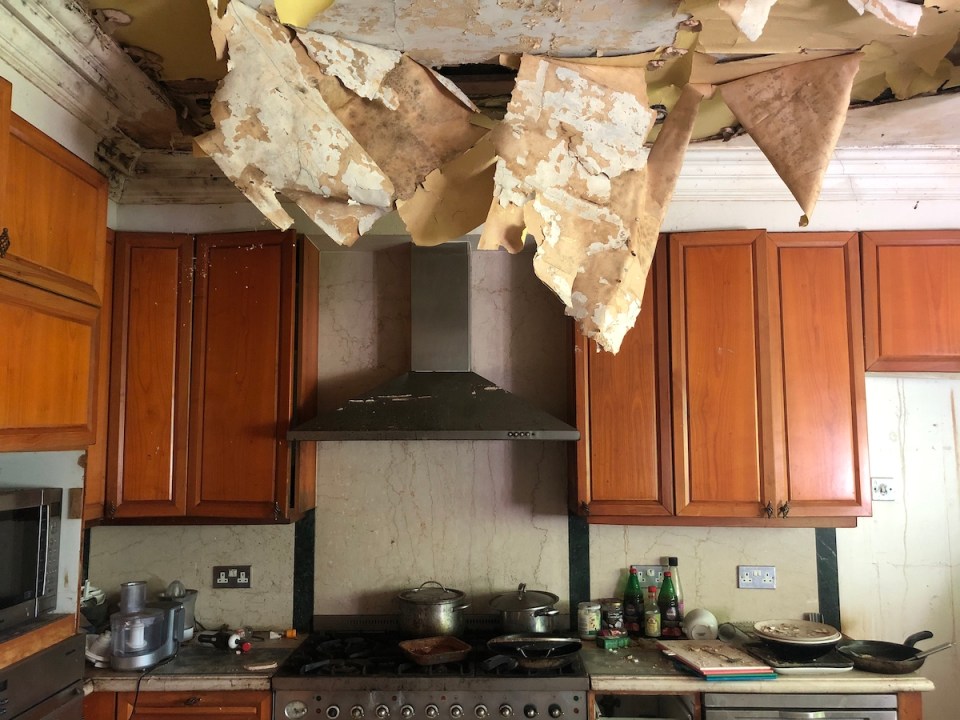  The ceiling in the kitchen has fallen in, although a dishwasher stacked with plates waits to be unloaded