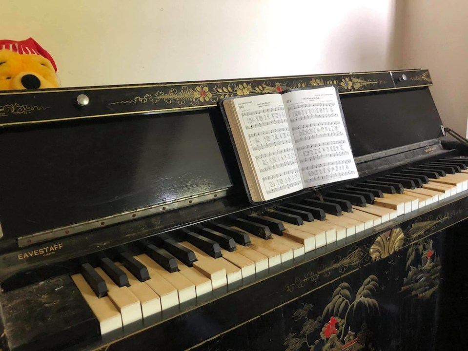  Inside the home, a piano waits to be played, with sheet music open for a musician