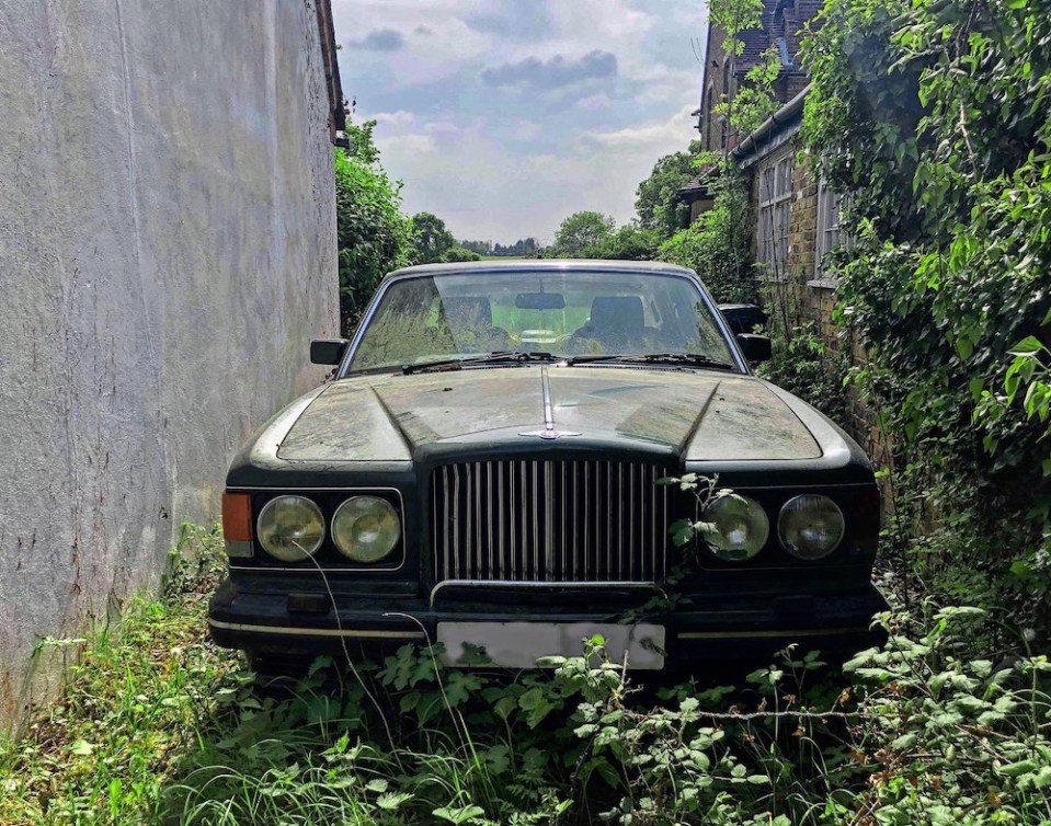  A Bentley has been left to rust on the driveway of the abandoned mansion