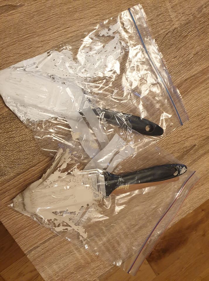 The woman stores her wet paintbrushes in a tightly sealed sandwich bag to stop them drying out