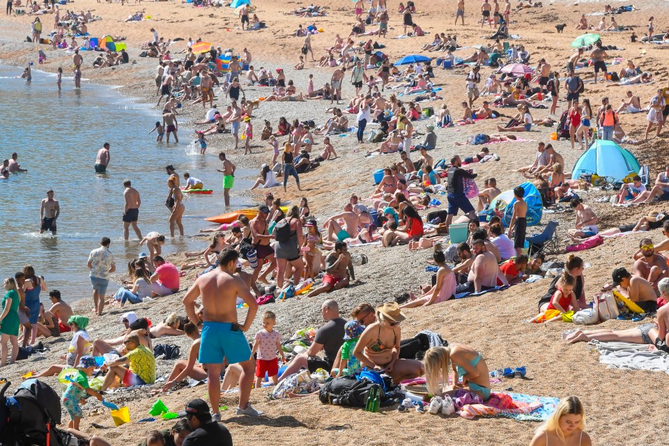 Thousands descended upon Durdle Door, Dorset, to enjoy the sizzling heat