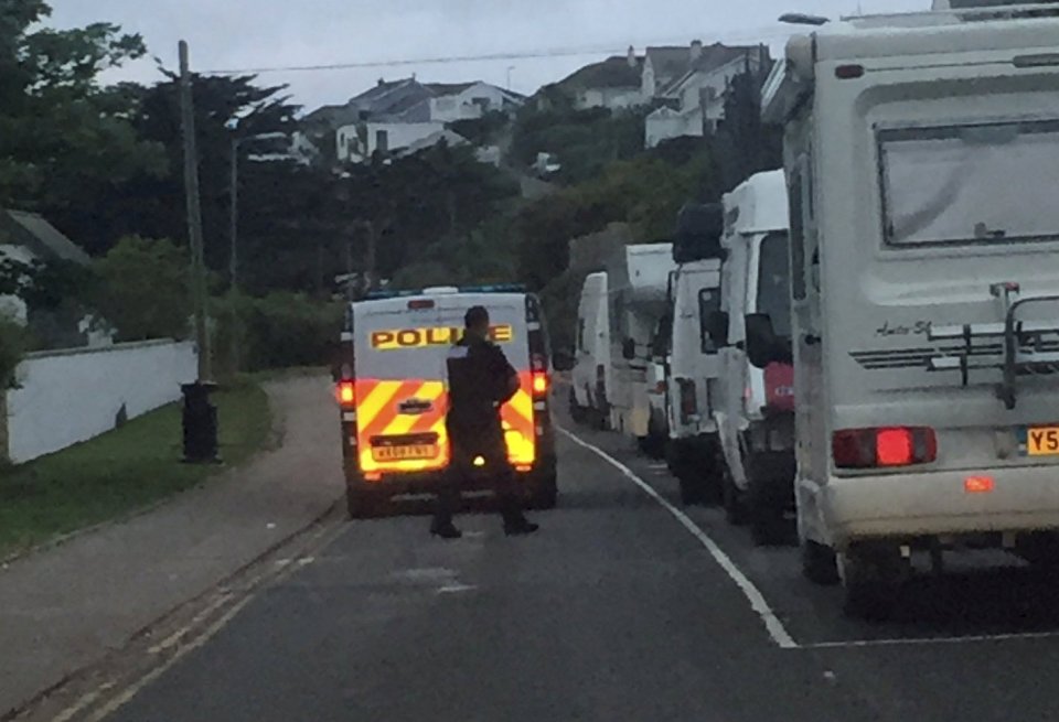  An officer can be seen walking alongside the vans that flouted the coronavirus rules