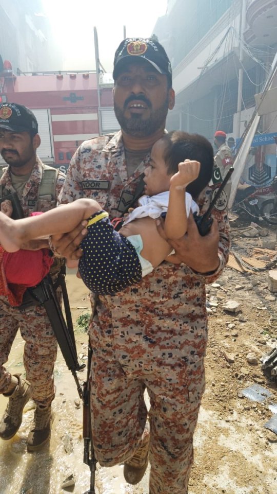  A child is carried away from the crash scene which left several houses destroyed