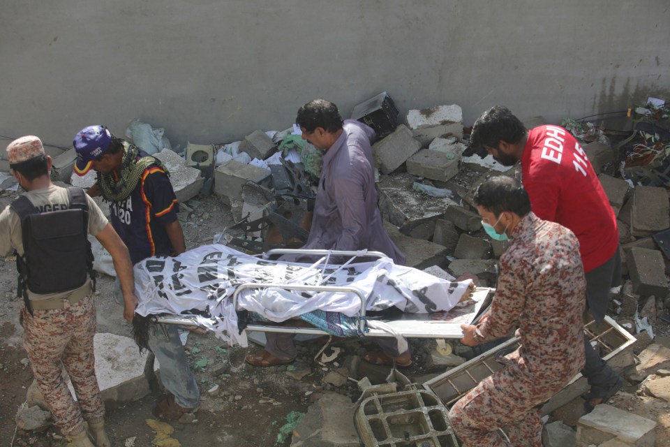  Emergency workers carry another body away from the scene of the deadly crash