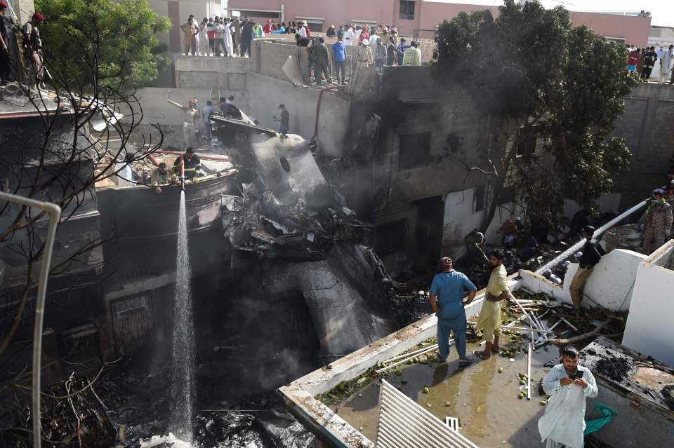  Smoking wreckage from the crash is seen in the packed residential area of Model Colony, Pakistan