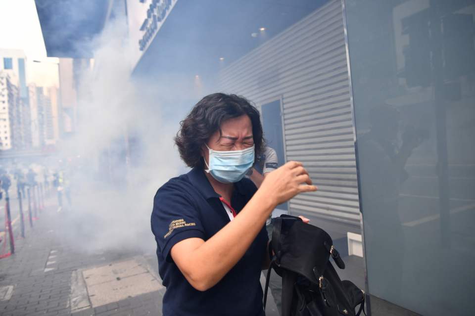  Protesters in masks were forced to flee when police fired teargas at them in Wanchai district