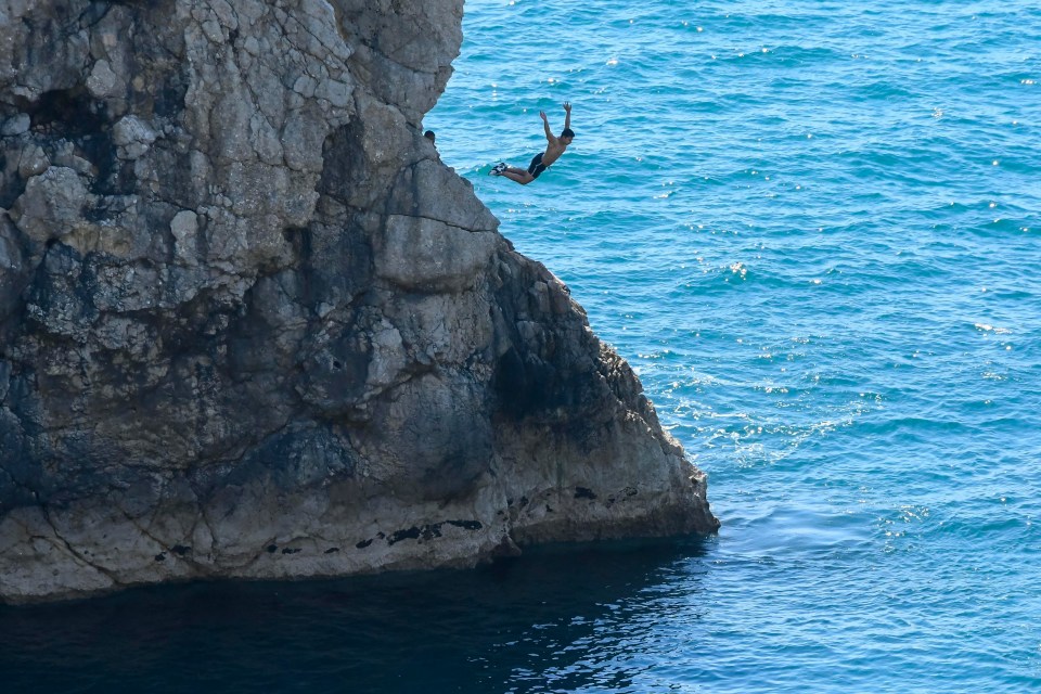 During an earlier incident, men were pictured plunging from the arch into the water below today