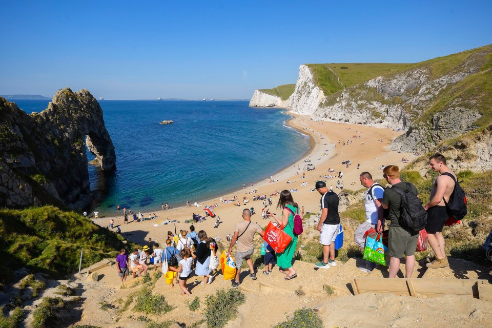 Visitors walking down the steps to the beach at Durdle Door at Lulworth on Sunday