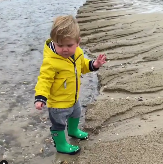  The famous chef filmed his little boy tottering in a shallow pool on the beach in his wellies