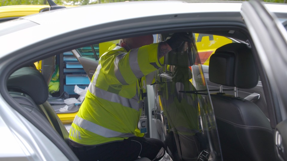 An AA worker installing a perspex screen in an Uber car amid the coronavirus pandemic 