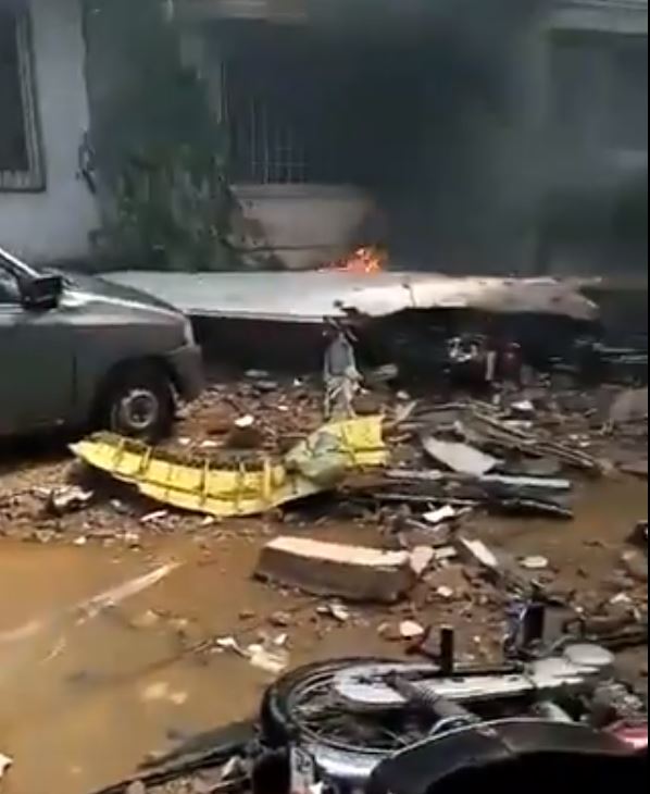  Debris from the plane is shown smouldering on the street following the crash in Model Colony, Pakistan