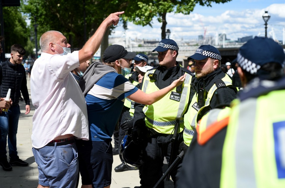 People from the pro-statue group shout at police officers attempting to keep the violence from escalating