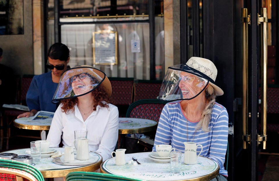 Women wearing protective visors have breakfast at the terrace of 'Cafe de Flore' in the Latin Quarter district in Paris